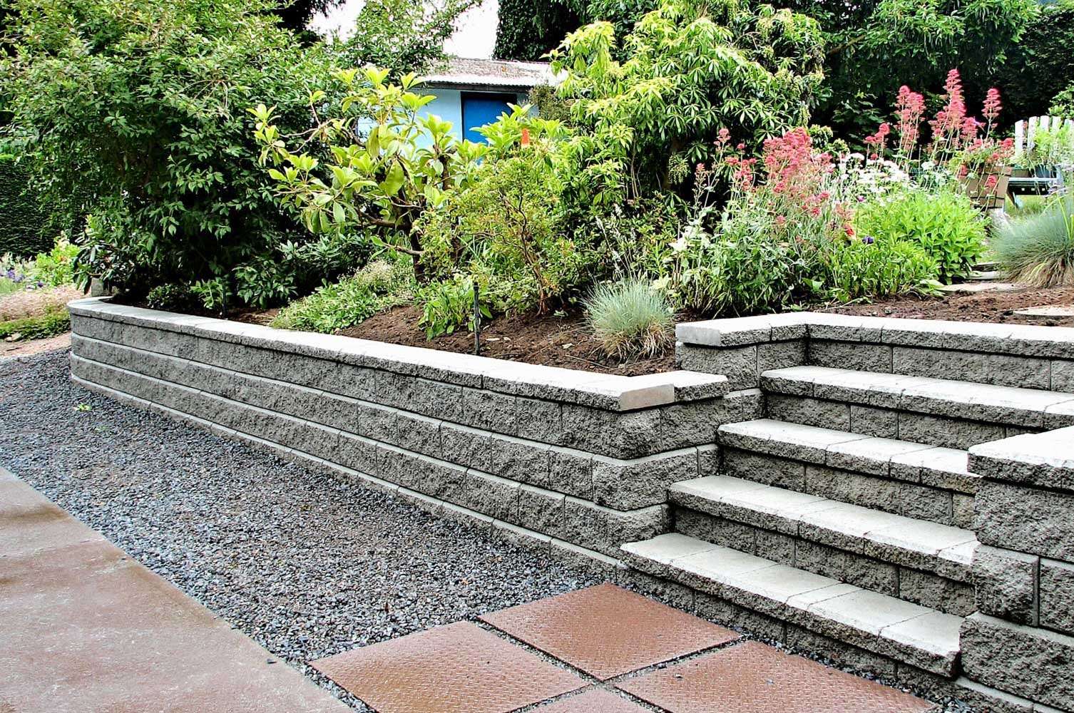 Retaining wall and masonry steps creating usable terraced space Retaining wall and masonry steps creating usable terraced space