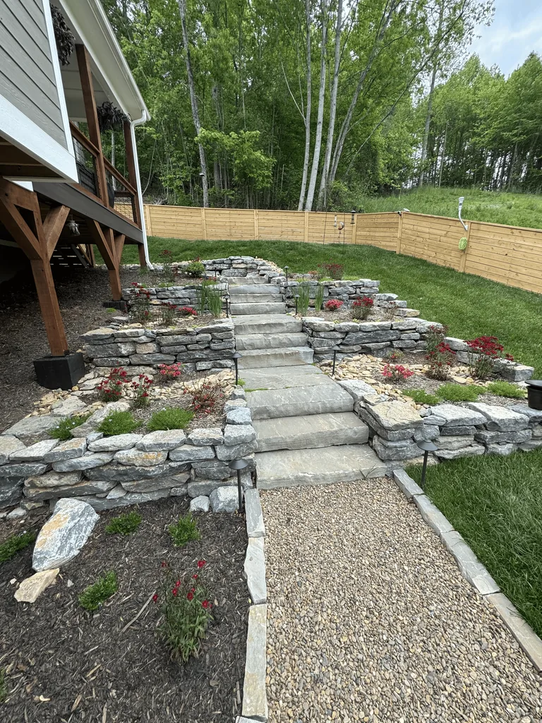 Tiered segmental retaining wall and masonry steps on a sloped property Tiered segmental retaining wall and masonry steps on a sloped property