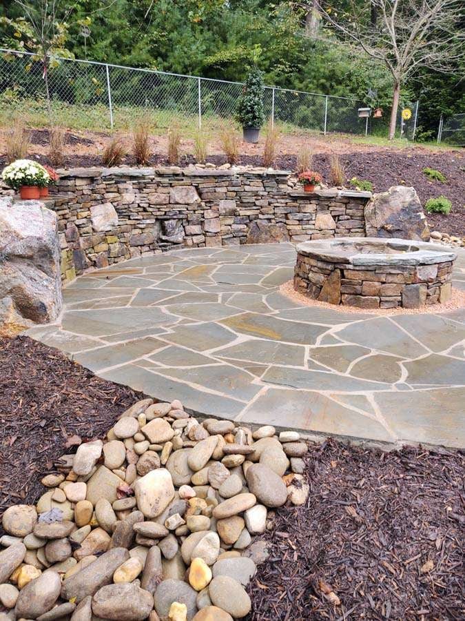 Laughter Family Hardscapes Hardscaping Services Buncombe County NC -02 The image depicts a recently finished hardscape project that utilizes pavers to pave the walkway, retaining wall and a fireplace.